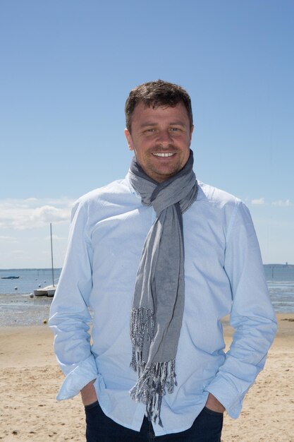 Portrait of smiling gorgeous handsome man with scarf relaxing on vacation