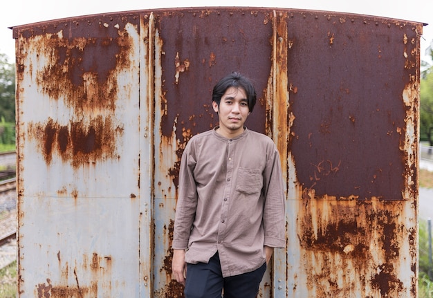 portrait of smiling handsome asian man standing in old vintage train 