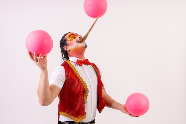 Portrait of smiling juggler juggling balls isolated on white background