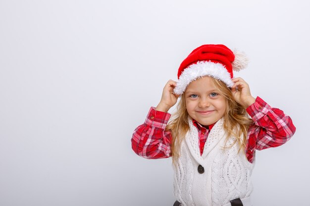 portrait of smiling little blonde girl in Santa hat on white  backgrounds