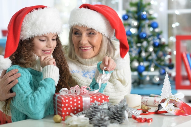 Portrait of smiling little girl with grandmother preparing for Christmas