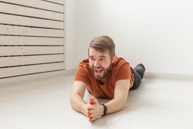 Photo portrait of smiling man sitting on floor