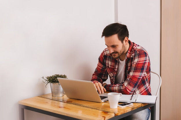 Portrait of a smiling man using laptop computer at home