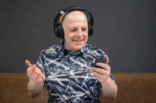 Portrait of a smiling man with headphones and a player in relaxation listening to his favorite music