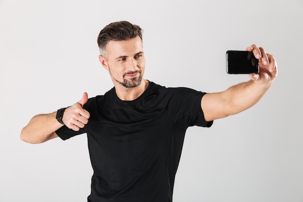 Portrait of a smiling mature sportsman taking a selfie