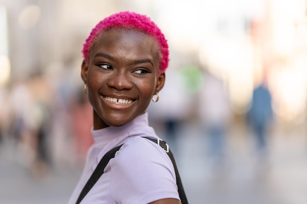 Portrait of a smiling modern stylish young afro woman outdoors