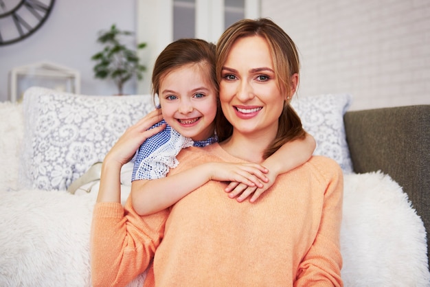 Portrait of smiling mom and her daughter looking at camera