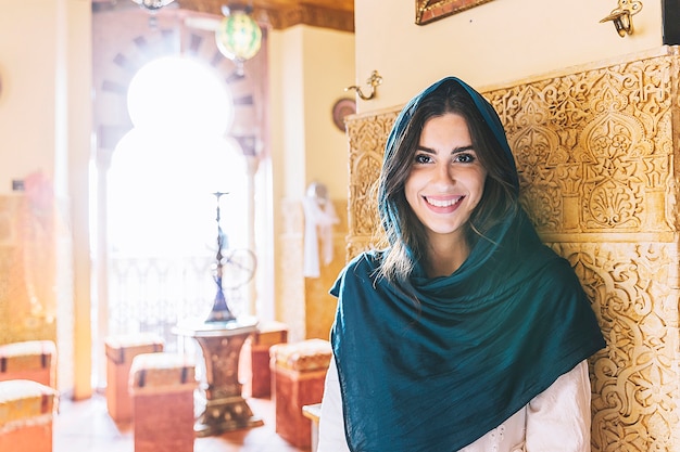 Portrait of smiling muslim woman in restaurant