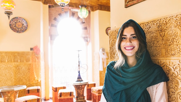 Portrait of smiling muslim woman in restaurant