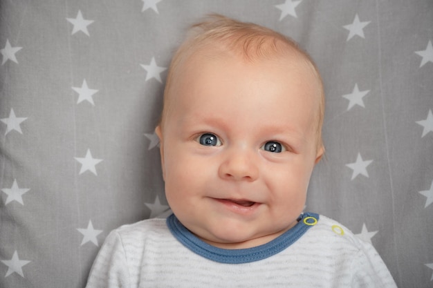 Portrait of smiling newborn baby with open mouth closeup Happy smiling child with blue eyes