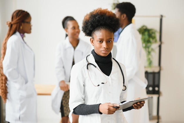 Portrait of a smiling nurse in front of her medical team