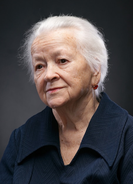 Portrait of smiling old woman on white background