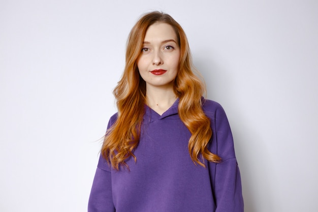 Portrait of a smiling red-haired woman in a purple hood