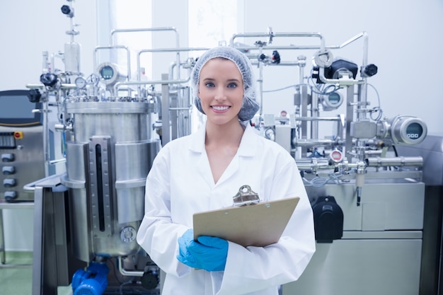 Portrait of a smiling scientist holding a clipboard