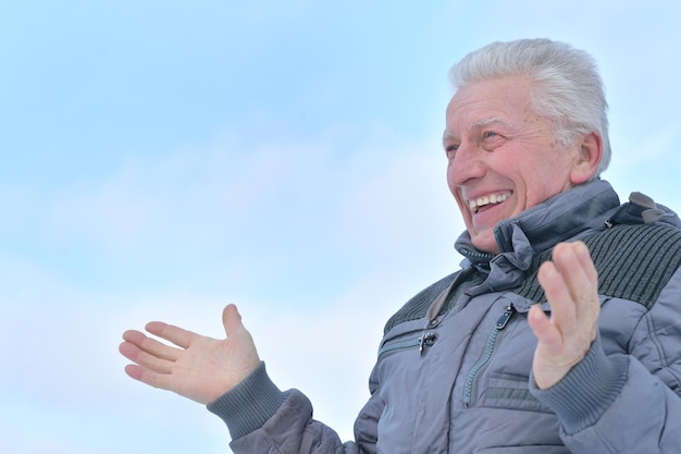 Portrait of smiling senior man standing outdoors in winter