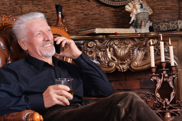 Photo portrait of smiling senior man talking on phone