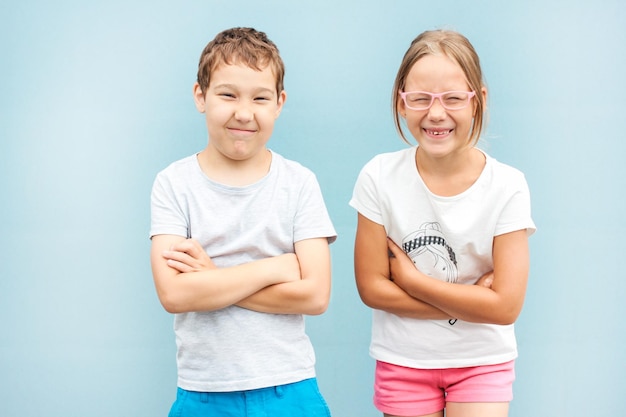 Photo portrait of smiling siblings against blue background