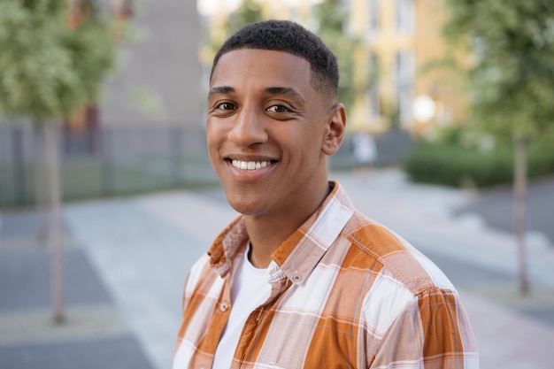 Portrait of smiling student looking at camera standing in university campus Education concept