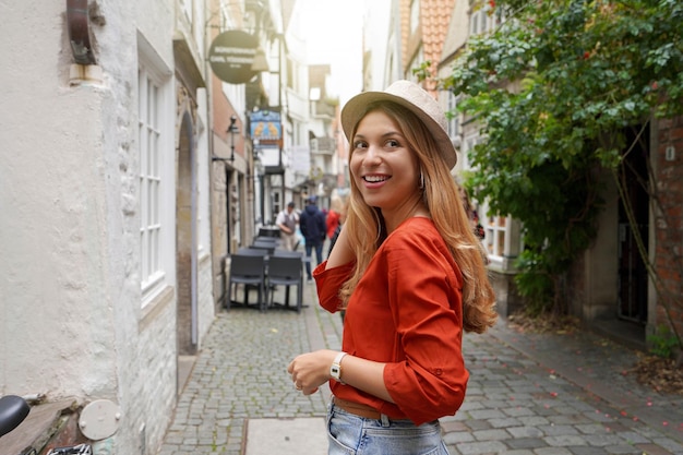 Portrait of smiling traveler woman in Schnoor neighborhood Bremen Germany