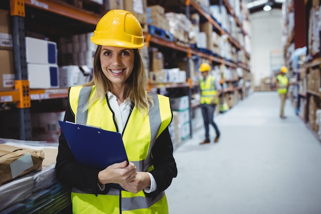 Portrait of smiling warehouse manager holding clipboard