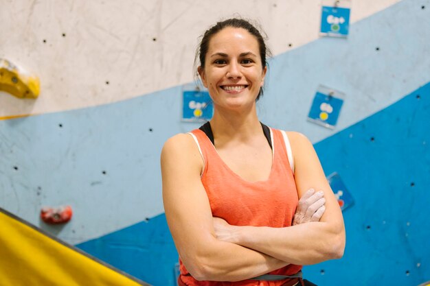 Portrait of smiling woman against climbing wall