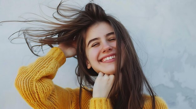 Photo portrait of a smiling woman gently touching her hair on a light gray background