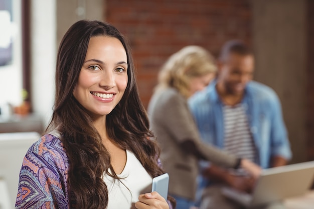 Portrait of smiling woman holding digital tablet in office