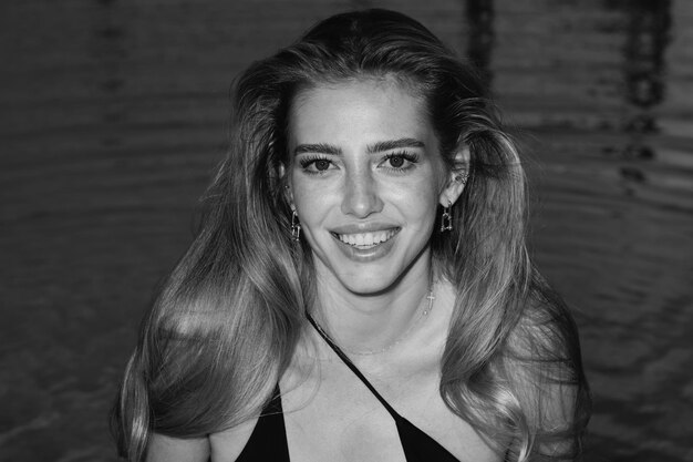 Portrait of smiling woman is posing near the swimming pool