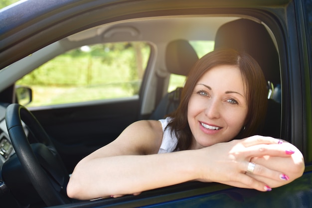 Portrait of a smiling woman sitting in the car