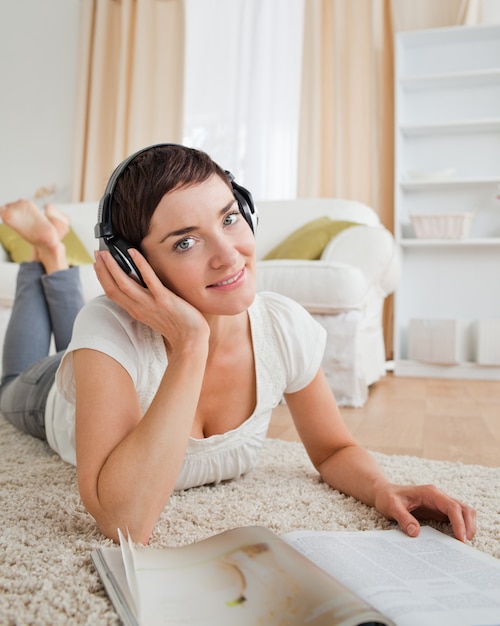 Portrait of a smiling woman with a magazine enjoying some music