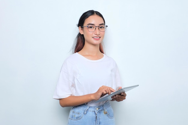 Portrait of smiling young Asian girl in white tshirt using digital tablet isolated on white background