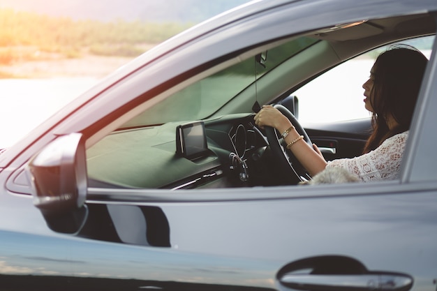 Portrait of smiling young asian woman driving a car.