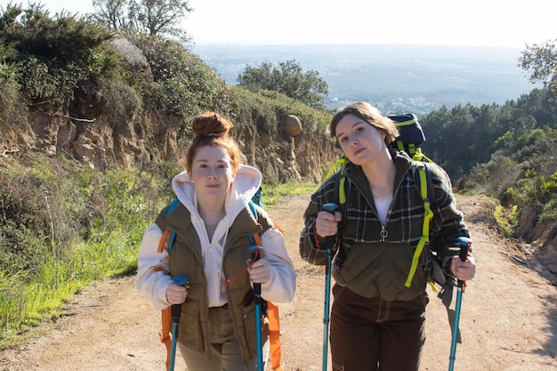 Portrait of smiling young backpackers hiking in countryside