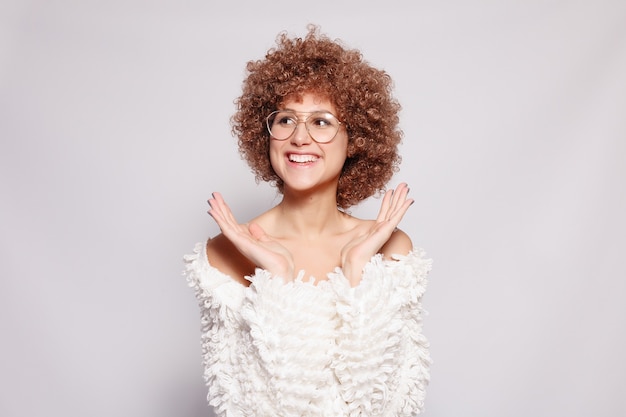 Photo portrait of smiling young black woman. portrait of a beautiful young woman with african american afro haircut and glamor makeup. studio shot. attractive girl wearing eyeglasses is surprised