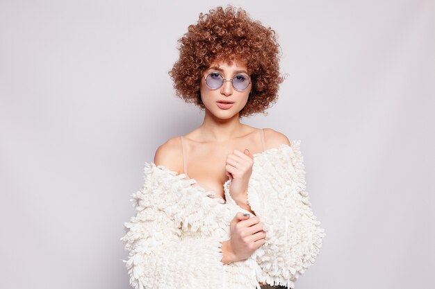 Portrait of smiling young black woman. Portrait of a beautiful young woman with African American afro haircut and glamor makeup. Studio shot. Attractive girl wearing eyeglasses.