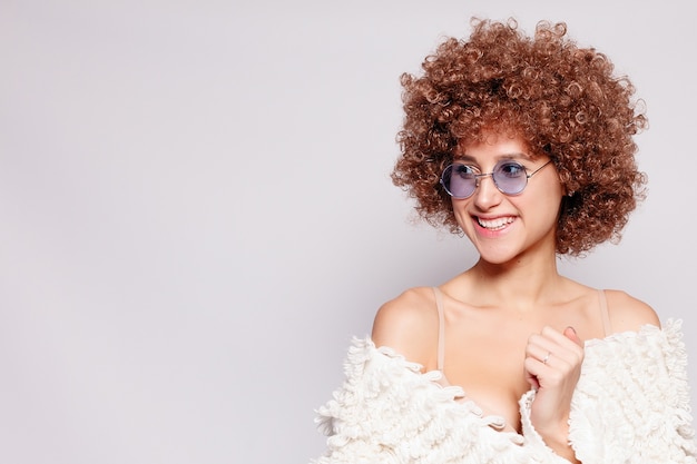 Photo portrait of smiling young black woman. portrait of a beautiful young woman with african american afro haircut and glamor makeup. studio shot. attractive girl wearing eyeglasses.