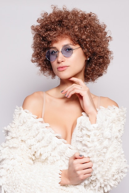 Portrait of smiling young black woman. Portrait of a beautiful young woman with African American afro haircut and glamor makeup. Studio shot. Attractive girl wearing eyeglasses.