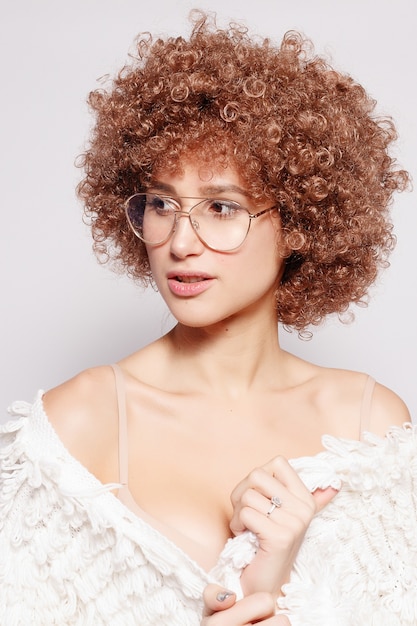 Portrait of smiling young black woman. Portrait of a beautiful young woman with African American afro haircut and glamor makeup. Studio shot. Attractive girl wearing eyeglasses.