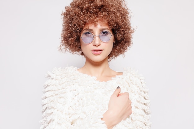 Portrait of smiling young black woman. Portrait of a beautiful young woman with African American afro haircut and glamor makeup. Studio shot. Attractive girl wearing eyeglasses.