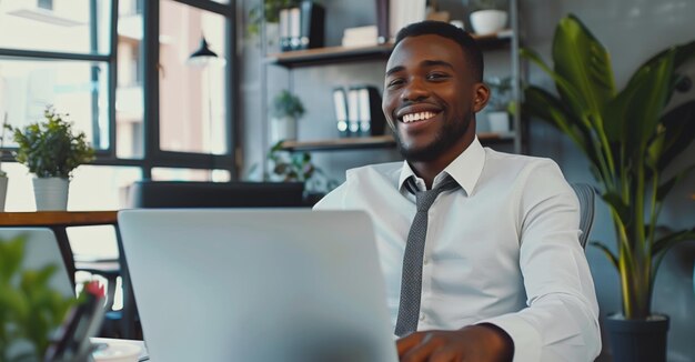 Portrait of a smiling young businessman working on his laptop in a modern office