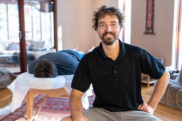 Photo portrait of smiling young man sitting at home