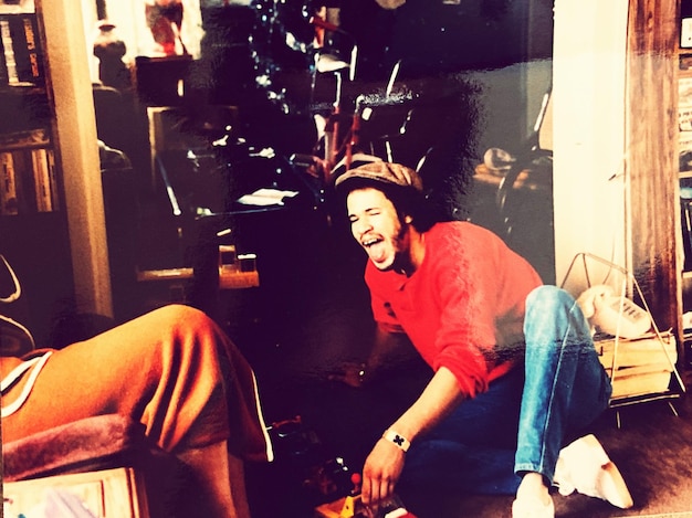 Photo portrait of smiling young man sitting at home