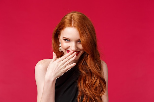 Photo portrait of a smiling young woman against red background