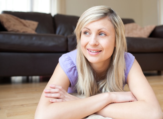 Portrait of a smiling young woman lying on the floor 