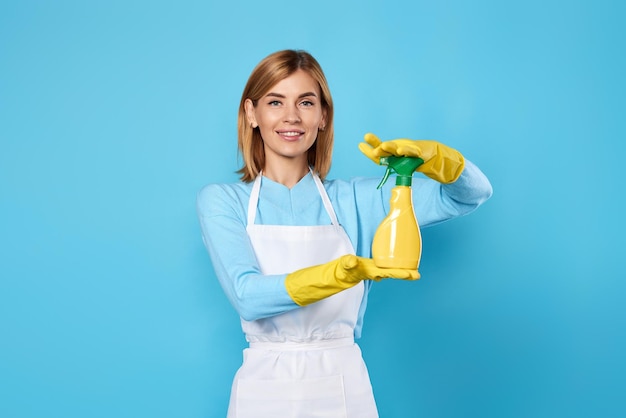 Portrait of smiling young woman standing against blue background