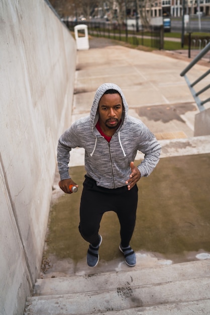 Portrait of a sport man running up on stairs outdoors. Fitness, sport and healthy lifestyle concepts.