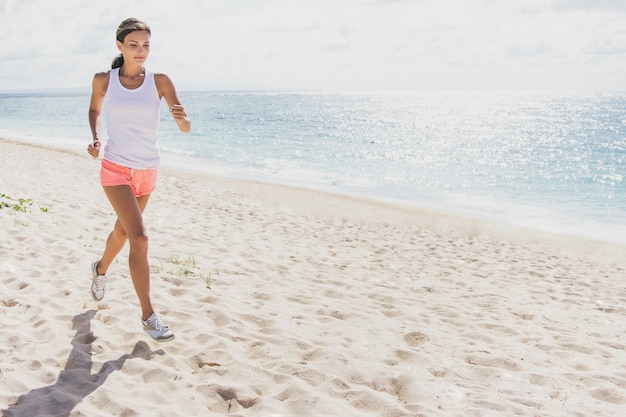 portrait of sporty woman jogging at the beach