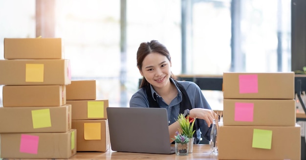 Portrait of Starting small businesses SME owners Asian woman check online orders Selling products online and working with boxs freelance work at home Asian sme business online small medium enterprise