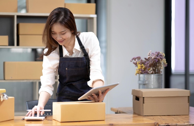 Portrait of Starting small businesses SME owners female entrepreneurs working on receipt box and check online orders to prepare to pack the boxes sell to customers sme business ideas online