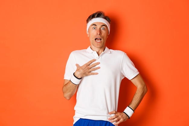 Portrait of startled middle aged guy in workout outfit